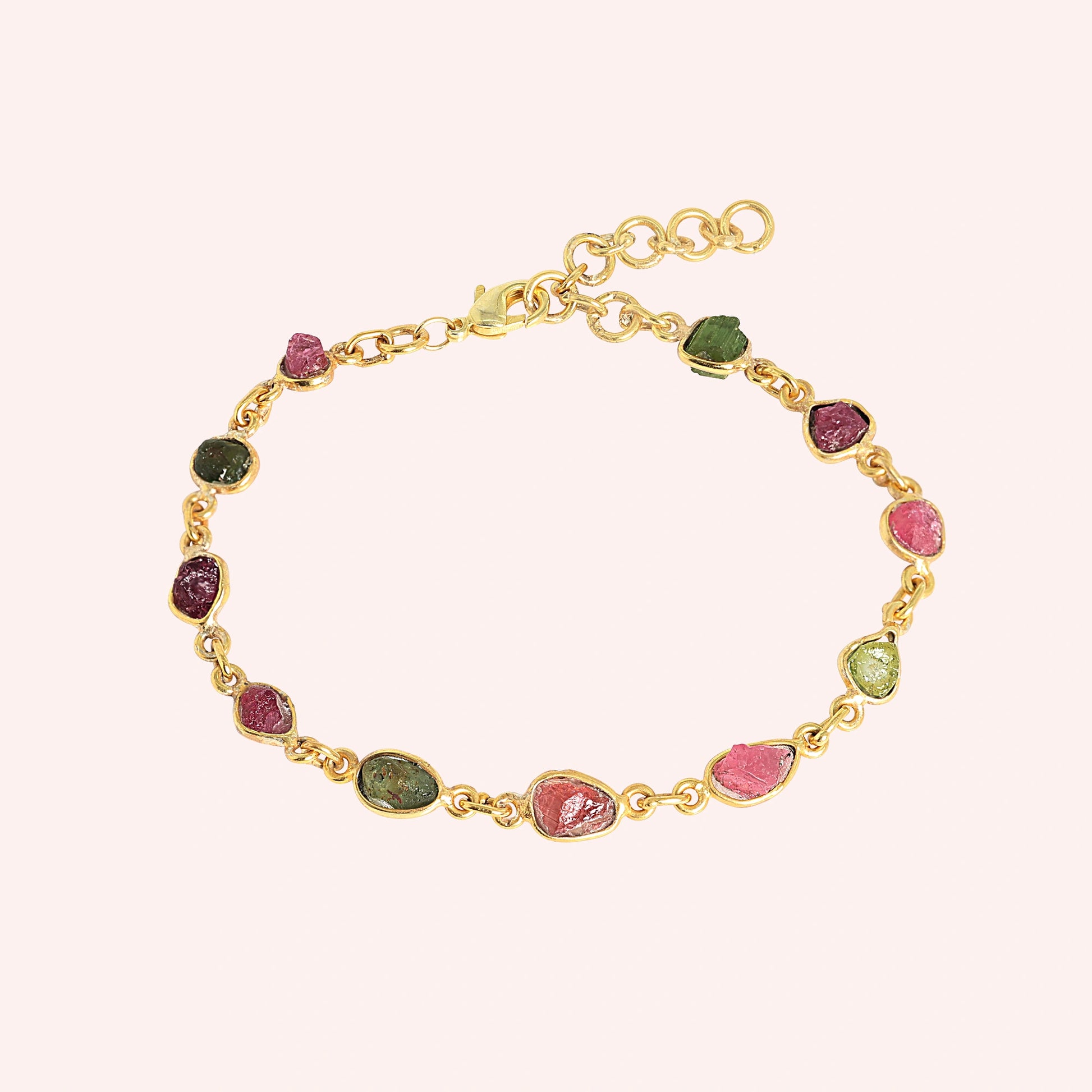 Tourmaline_bracelet_with_rough_tourmaline_stones_in_gold_plated_silver_at_front_angle_view_on_solid_pink_background