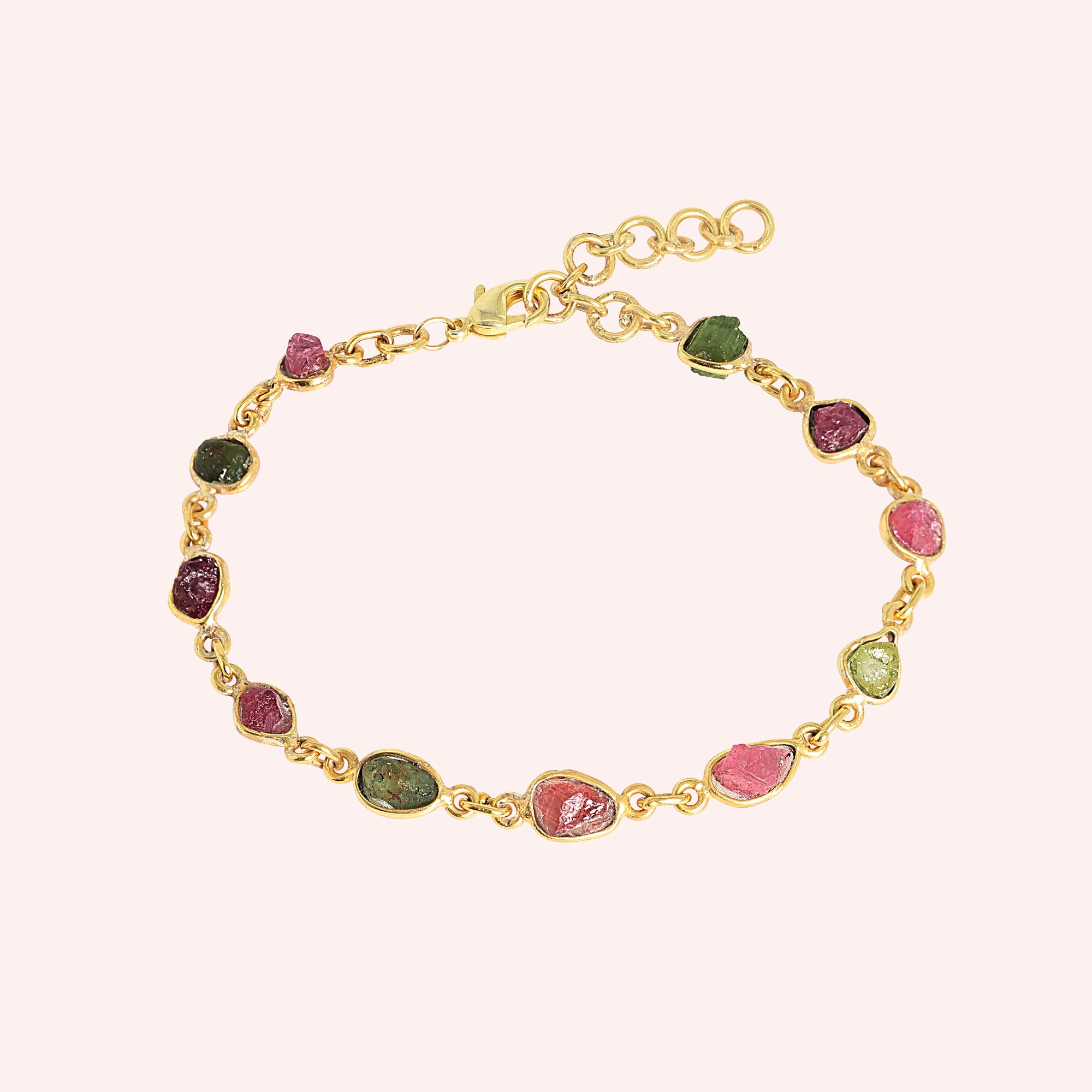Tourmaline_bracelet_with_rough_tourmaline_stones_in_gold_plated_silver_at_front_angle_view_on_solid_pink_background
