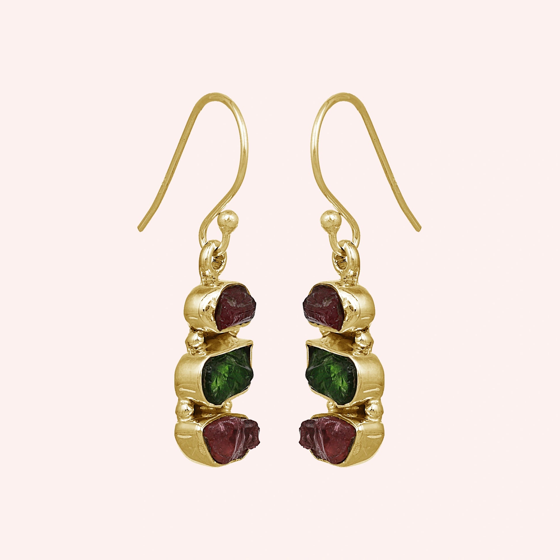 Trending_earrings_in_gold_plated_silver_with_three_raw_tourmaline_stones_at_slight_angle_view_on_solid_pink_background