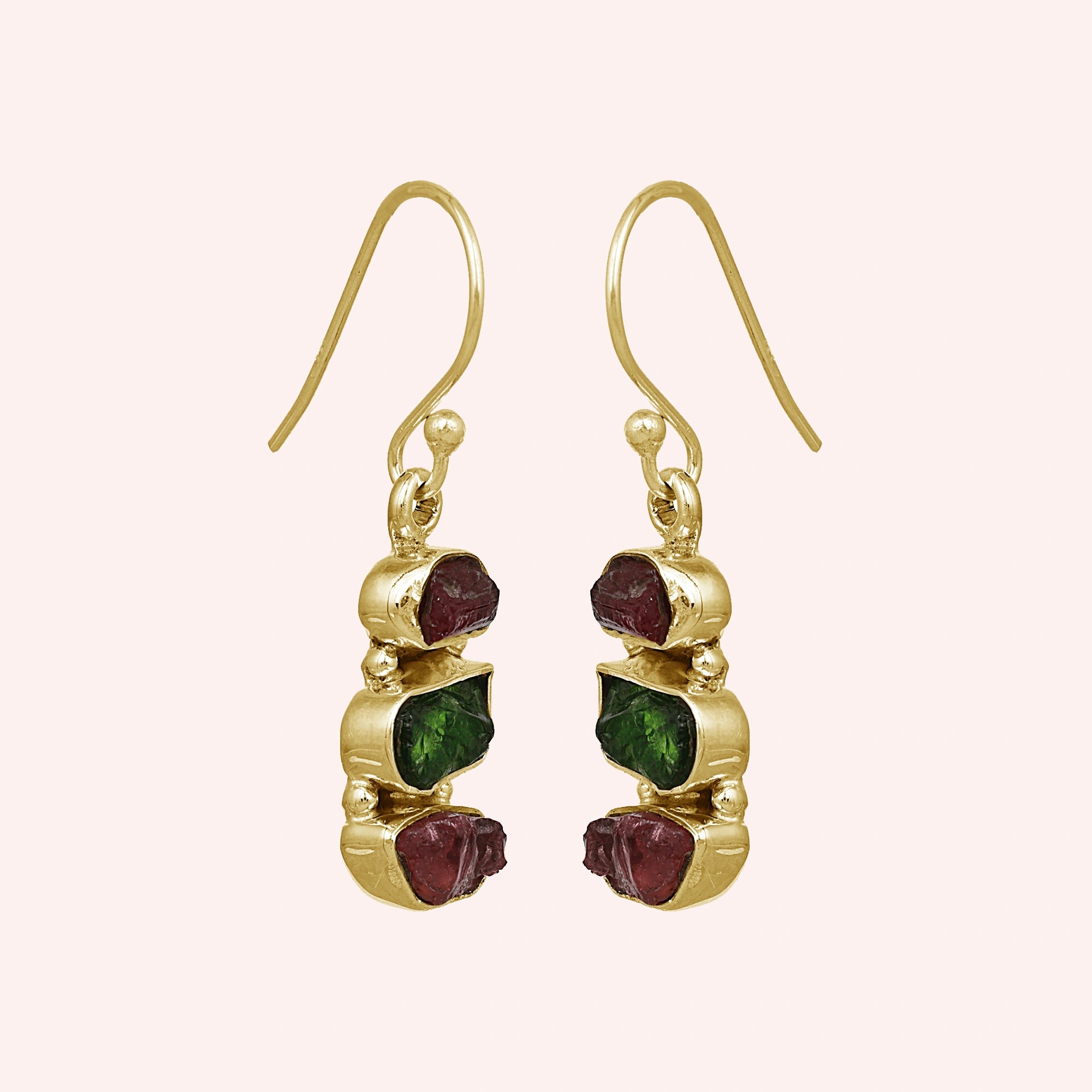 Trending_earrings_in_gold_plated_silver_with_three_raw_tourmaline_stones_at_slight_angle_view_on_solid_pink_background