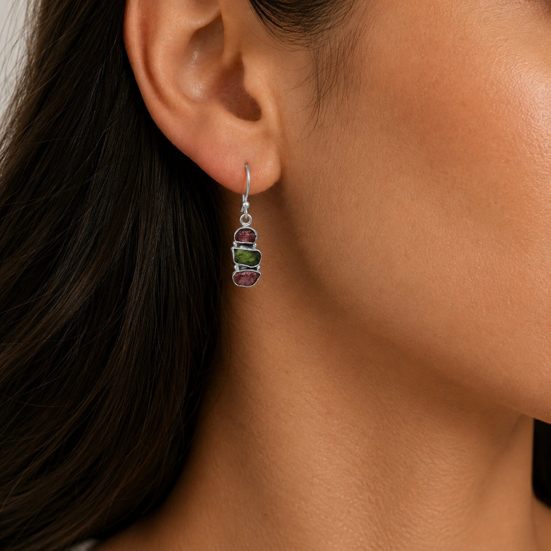 Trending_earrings_in_gold_plated_silver_with_three_raw_tourmaline_stones_at_front_angle_view_on_soft_fabric_background