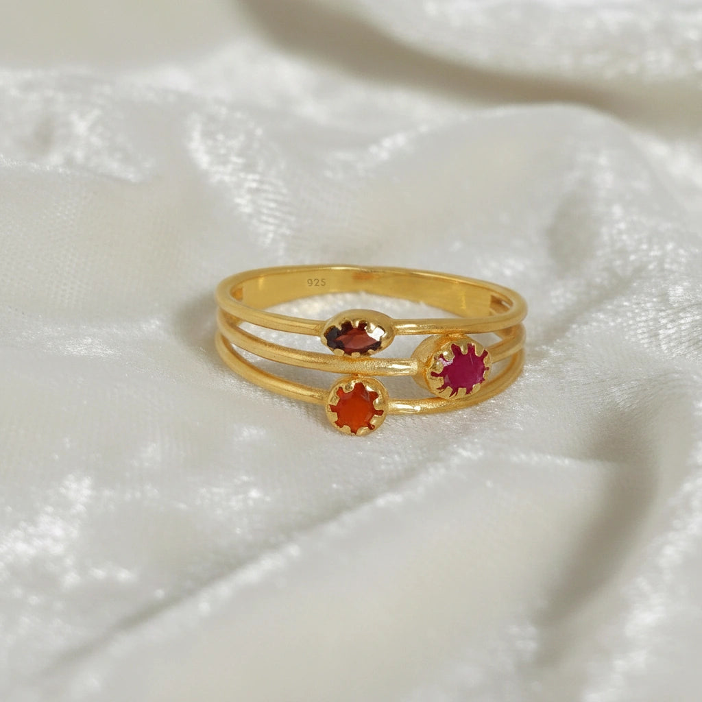 Triple-band-ring-with-ruby-garnet-and-carnelian-on-white-satin-background-prong-set-multi-stone-ring