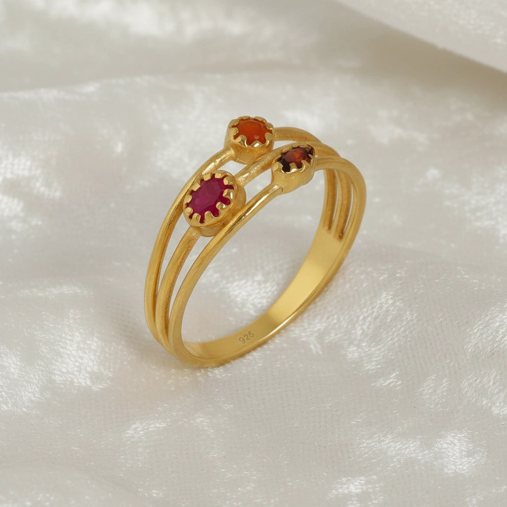 Triple-band-ring-with-ruby-carnelian-and-garnet-gemstones-in-gold-plated-silver-on-white-satin-background
