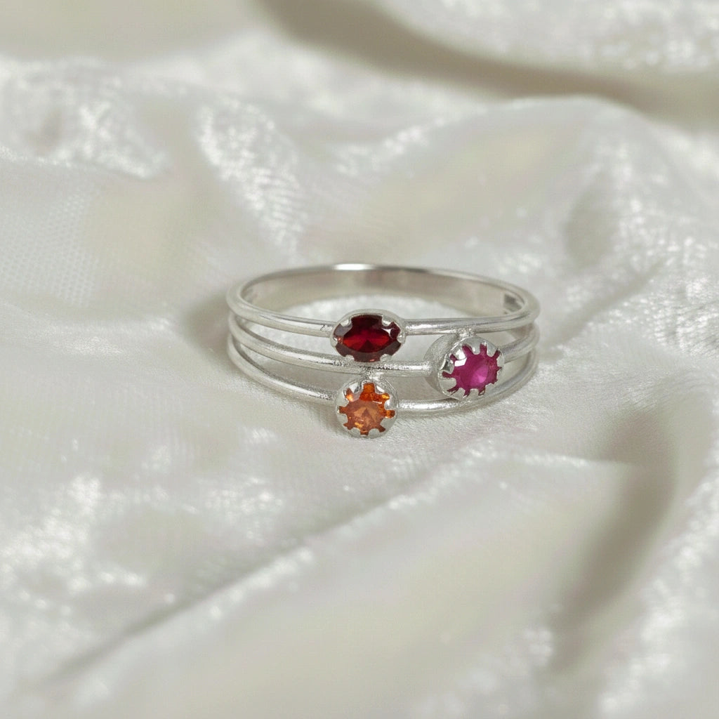 Triple-band-ring-with-ruby-carnelian-and-garnet-gemstones-in-sterling-silver-on-white-satin-background