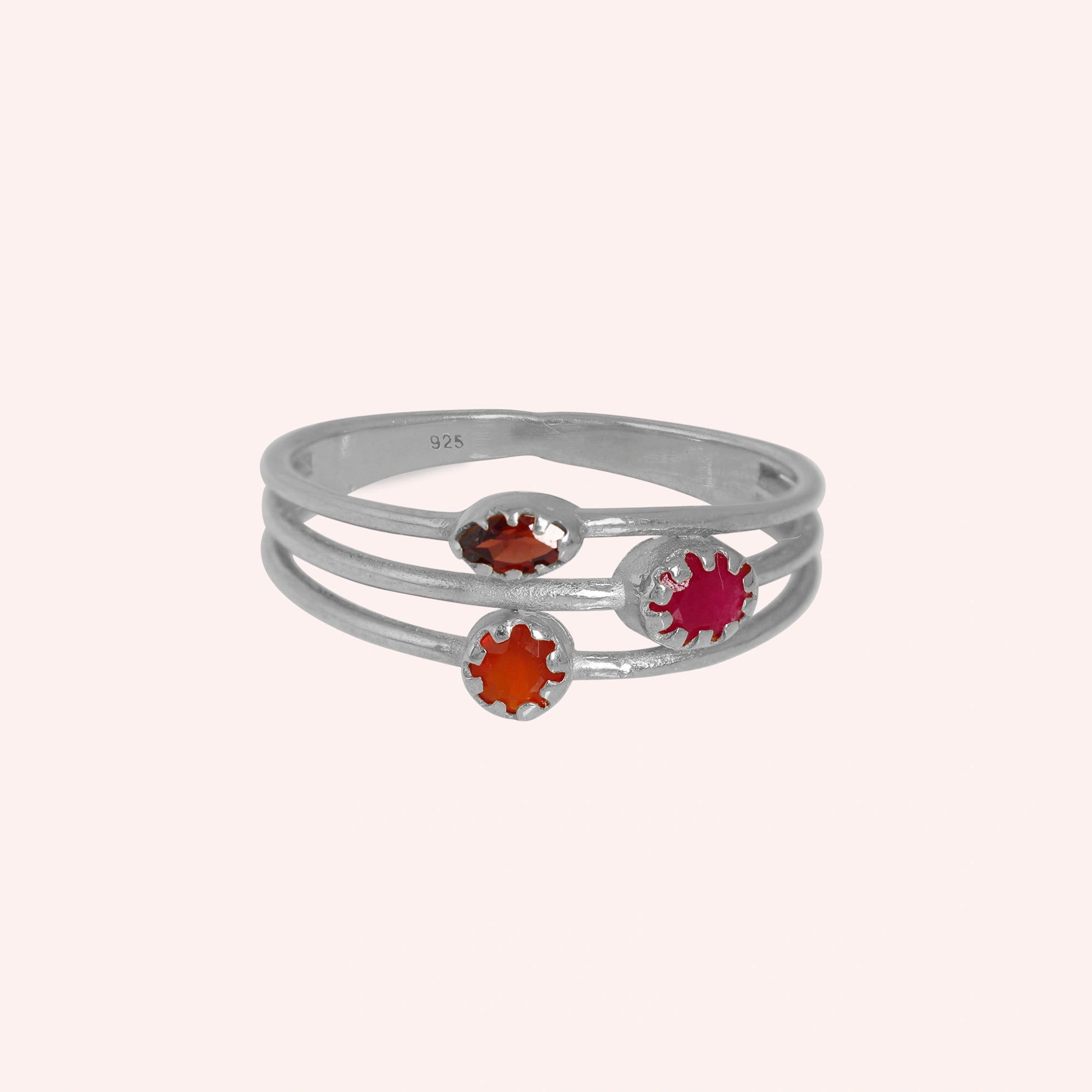 Triple-band-ring-with-ruby-carnelian-and-garnet-gemstones-in-sterling-silver-on-soft-pink-background