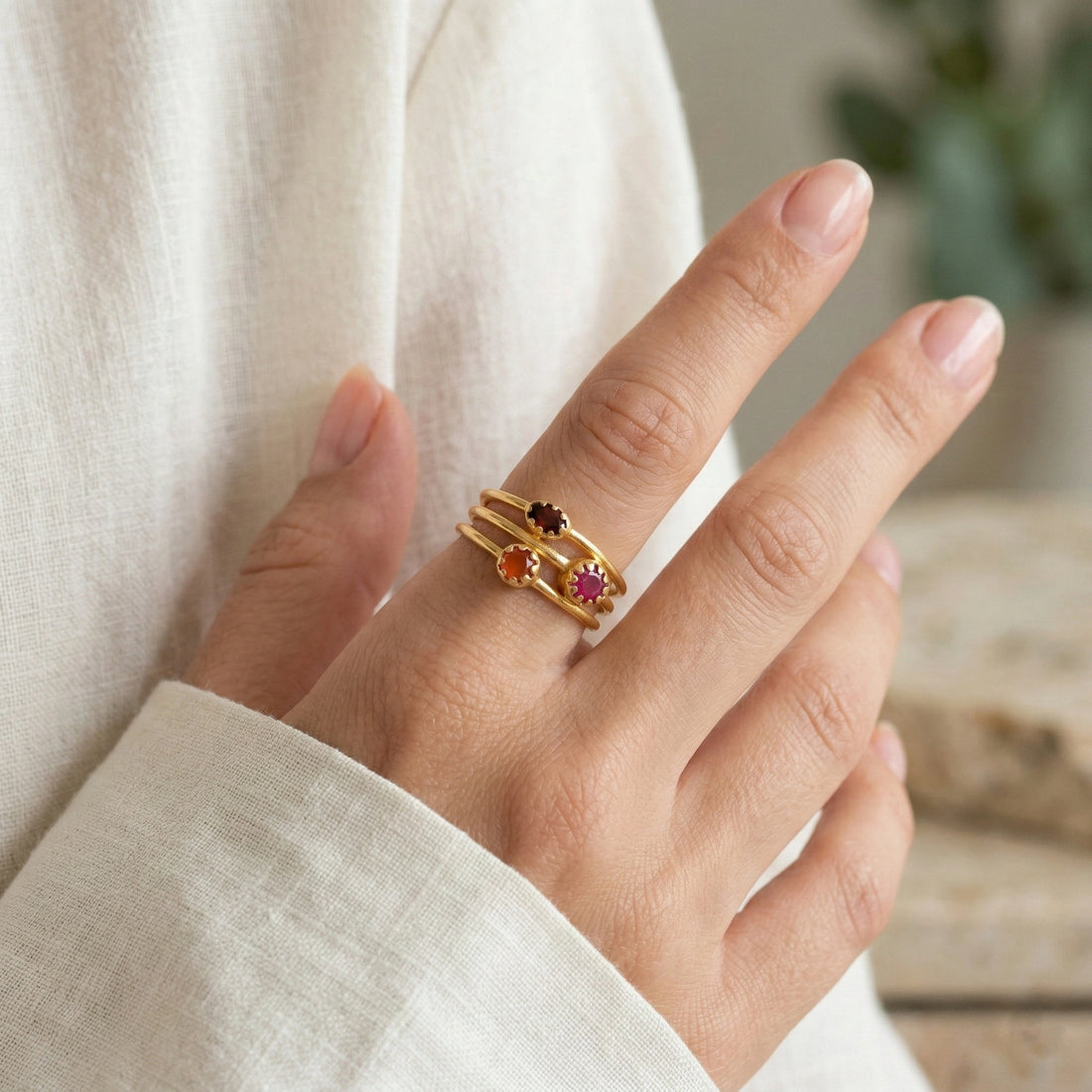 Triple-band-ring-with-ruby-garnet-and-carnelian-on-white-satin-background-prong-set-multi-stone-ring