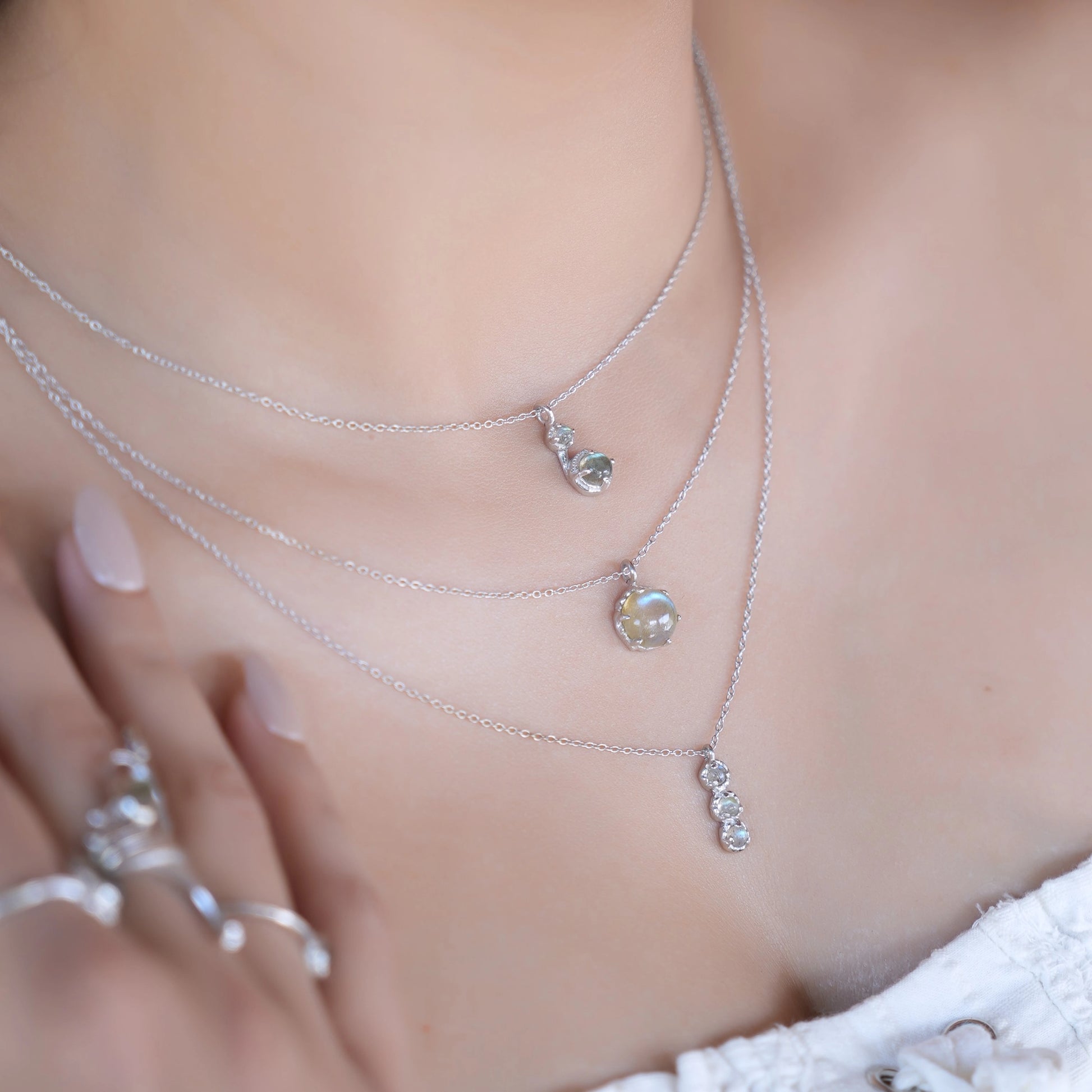 Labradorite necklace featuring three silver layers with flashing stones worn on a model's neck side-profile angle