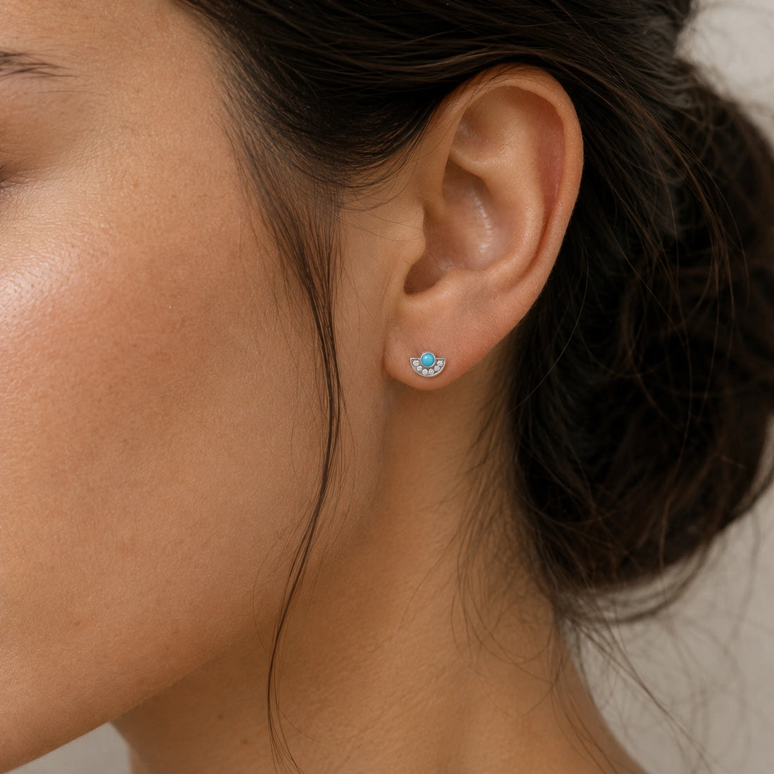 Turquoise_earrings_in_gold_plated_silver_with_turquoise_and_CZ_stones_at_slight_angle_view_on_soft_fabric_background