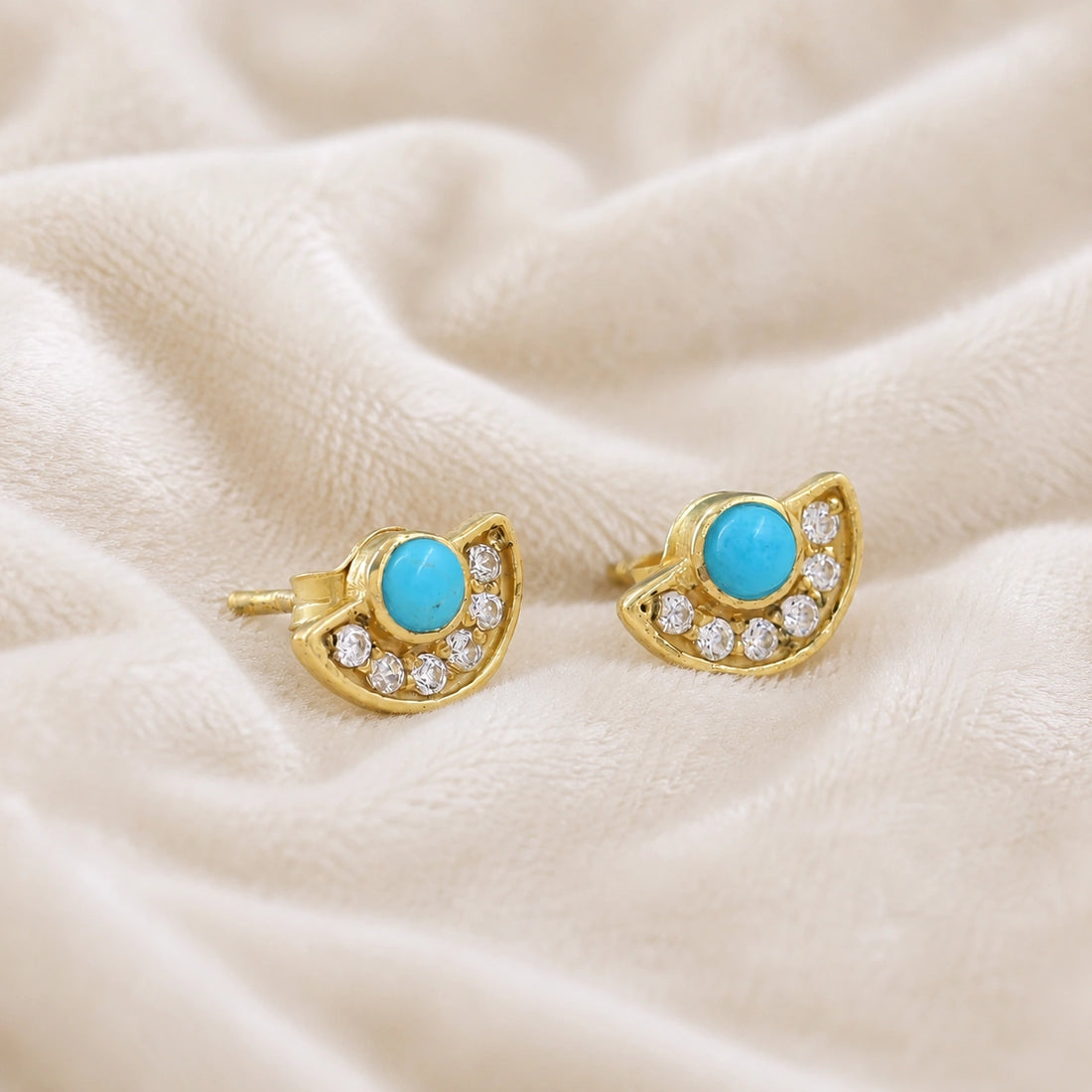 Turquoise_earrings_in_gold_plated_silver_with_turquoise_and_CZ_stones_at_slight_angle_view_on_soft_fabric_background