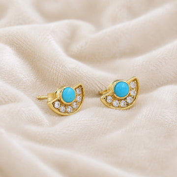 Turquoise_earrings_in_gold_plated_silver_with_turquoise_and_CZ_stones_at_slight_angle_view_on_soft_fabric_background