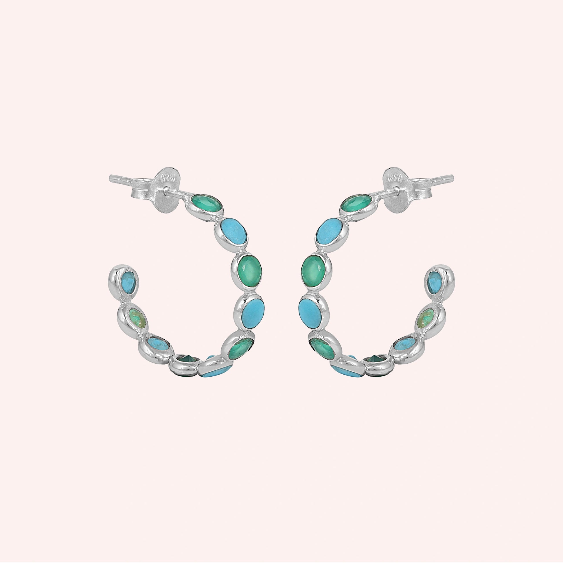 Sterling silver turquoise hoop earrings with green onyx stones a beautiful product focus on a pink background straight on view