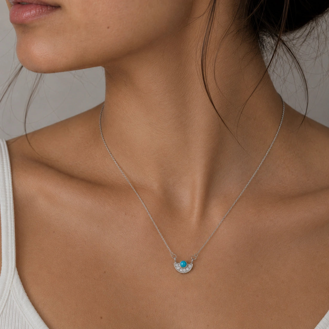 Turquoise_necklace_in_gold_plated_silver_with_turquoise_and_CZ_stones_at_slight_angle_view_on_soft_fabric_background