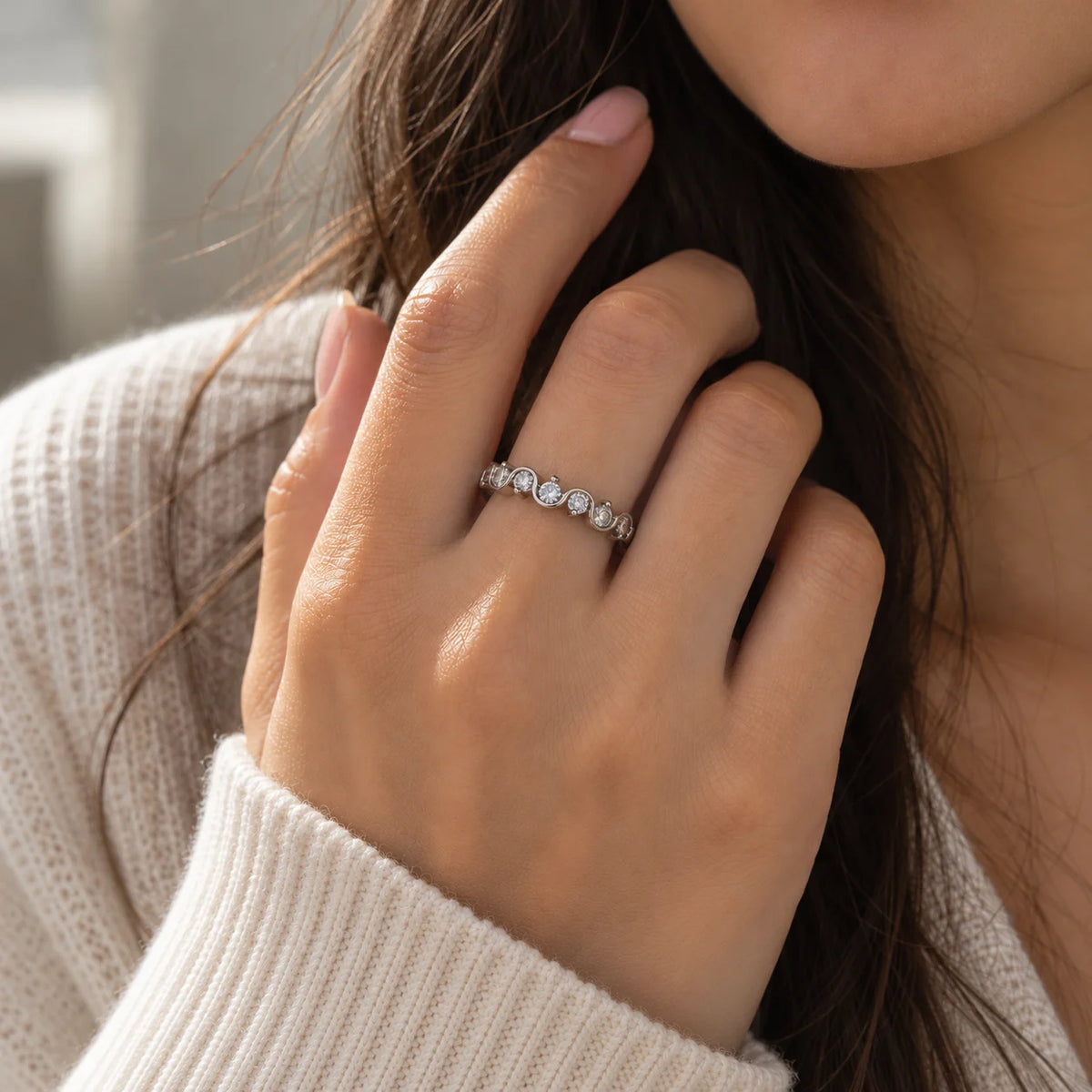 Wave_ring_in_sterling_silver_in_half_eternity_design_with_CZ_stones_at_front_view_on_worn_by_a_model