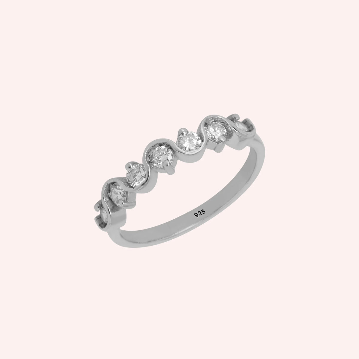 Wave_ring_in_sterling_silver_in_half_eternity_design_with_CZ_stones_at_side_view_on_solid_pink_background