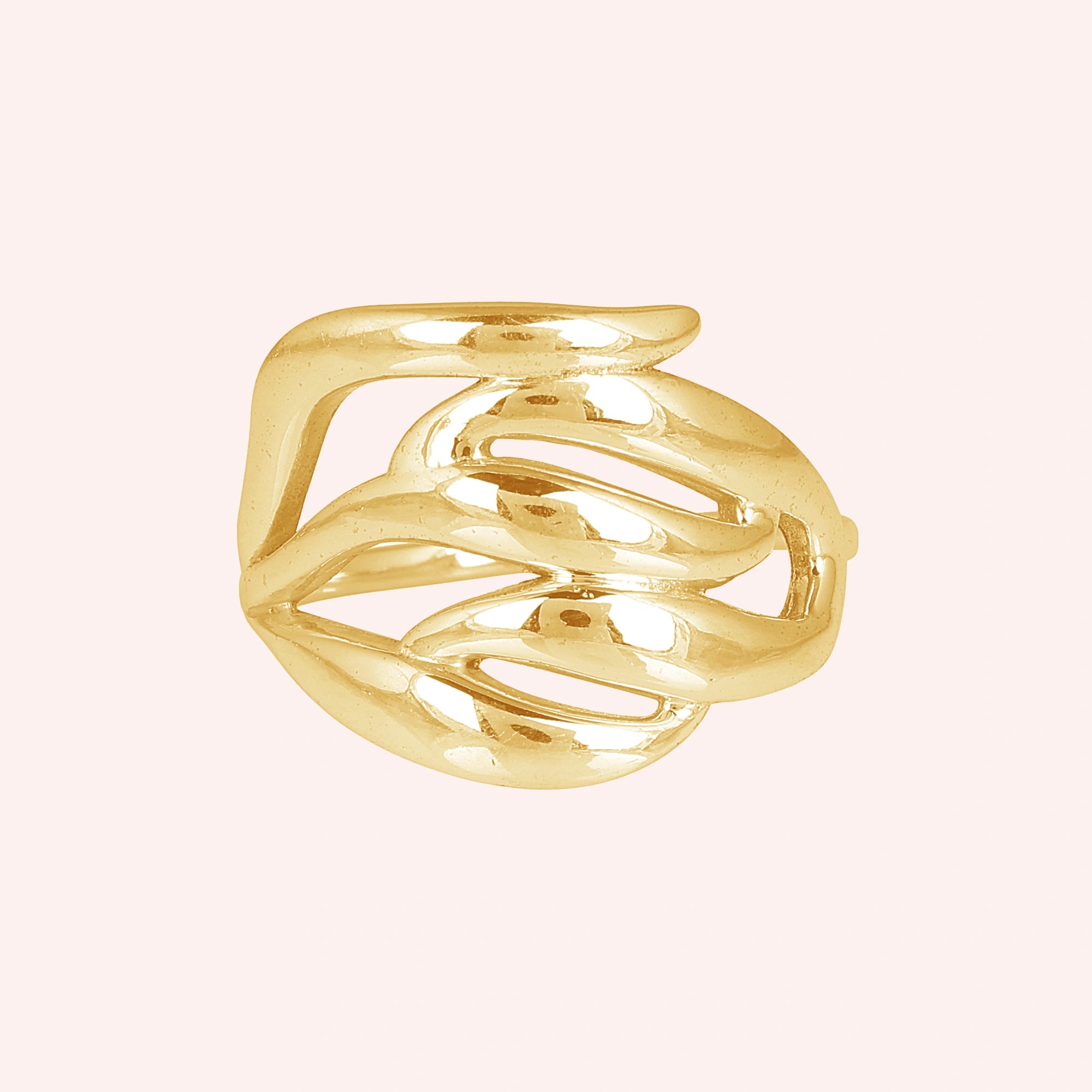 wave ring featuring a flowing gold-plated design as a statement ring over a pink background from a front on angle