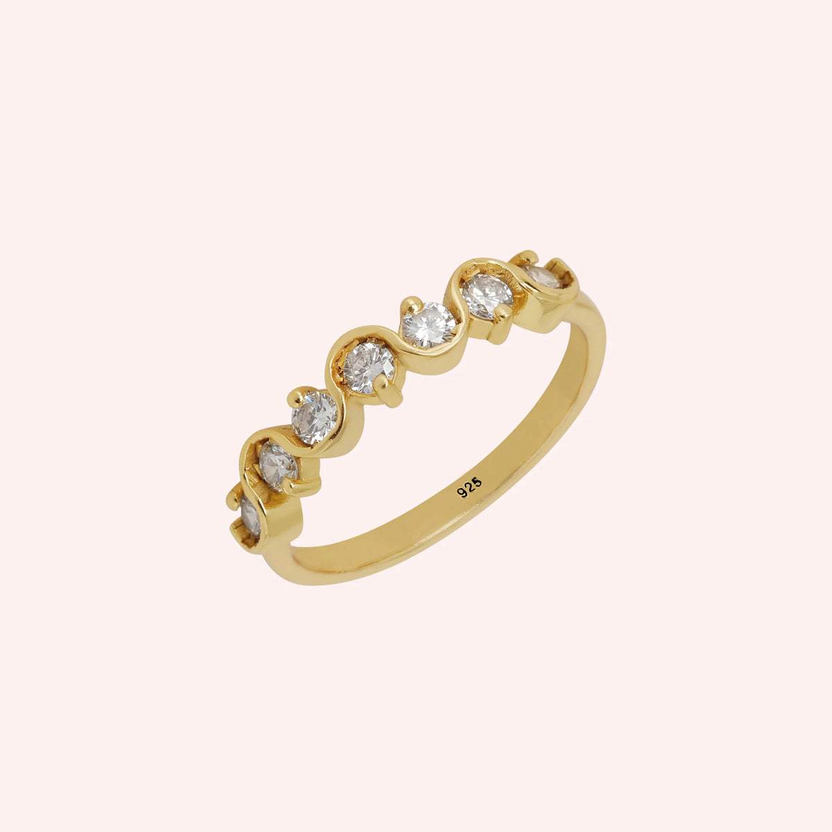 Wave_ring_in_gold_plated_silver_in_half_eternity_design_with_CZ_stones_at_side_view_on_solid_pink_background