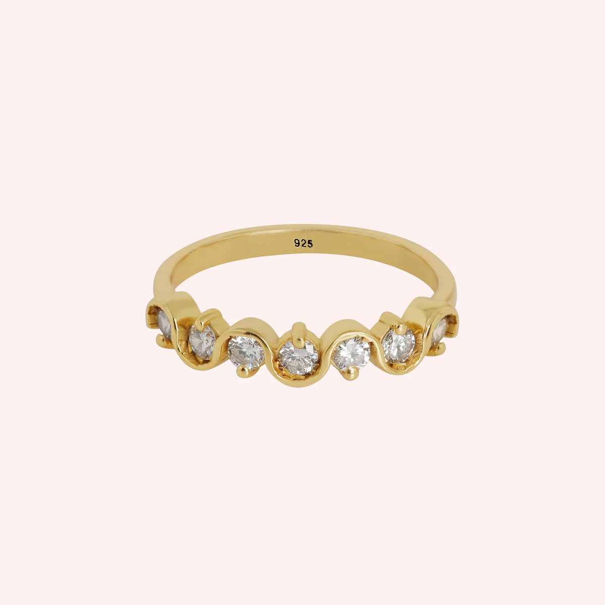 Wave_ring_in_gold_plated_silver_in_half_eternity_design_with_CZ_stones_at_front_view_on_solid_pink_background