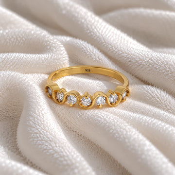 Wave_ring_in_gold_plated_silver_in_half_eternity_design_with_CZ_stones_at_front_angle_view_on_soft_fabric_background