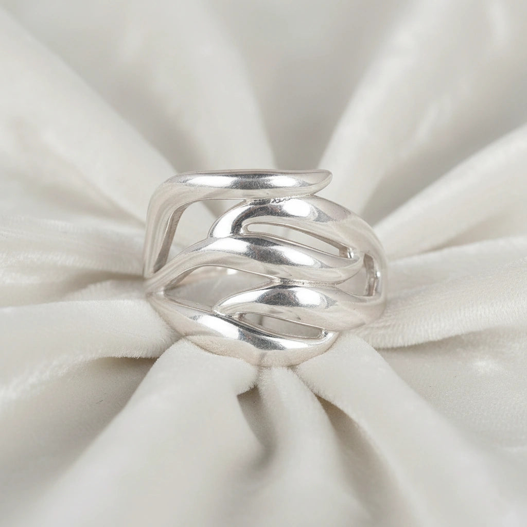 wave ring featuring a flowing silver design as a statement ring over white fabric from a front view angle