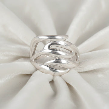 wave ring featuring a flowing silver design as a statement ring over white fabric from a front view angle