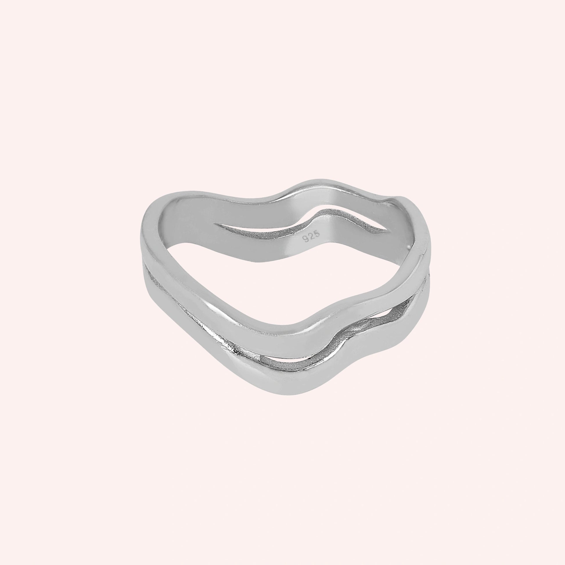 A straight view of a double layered wave ring silver band ring with 925 stamp with an organic shape on a light pink background