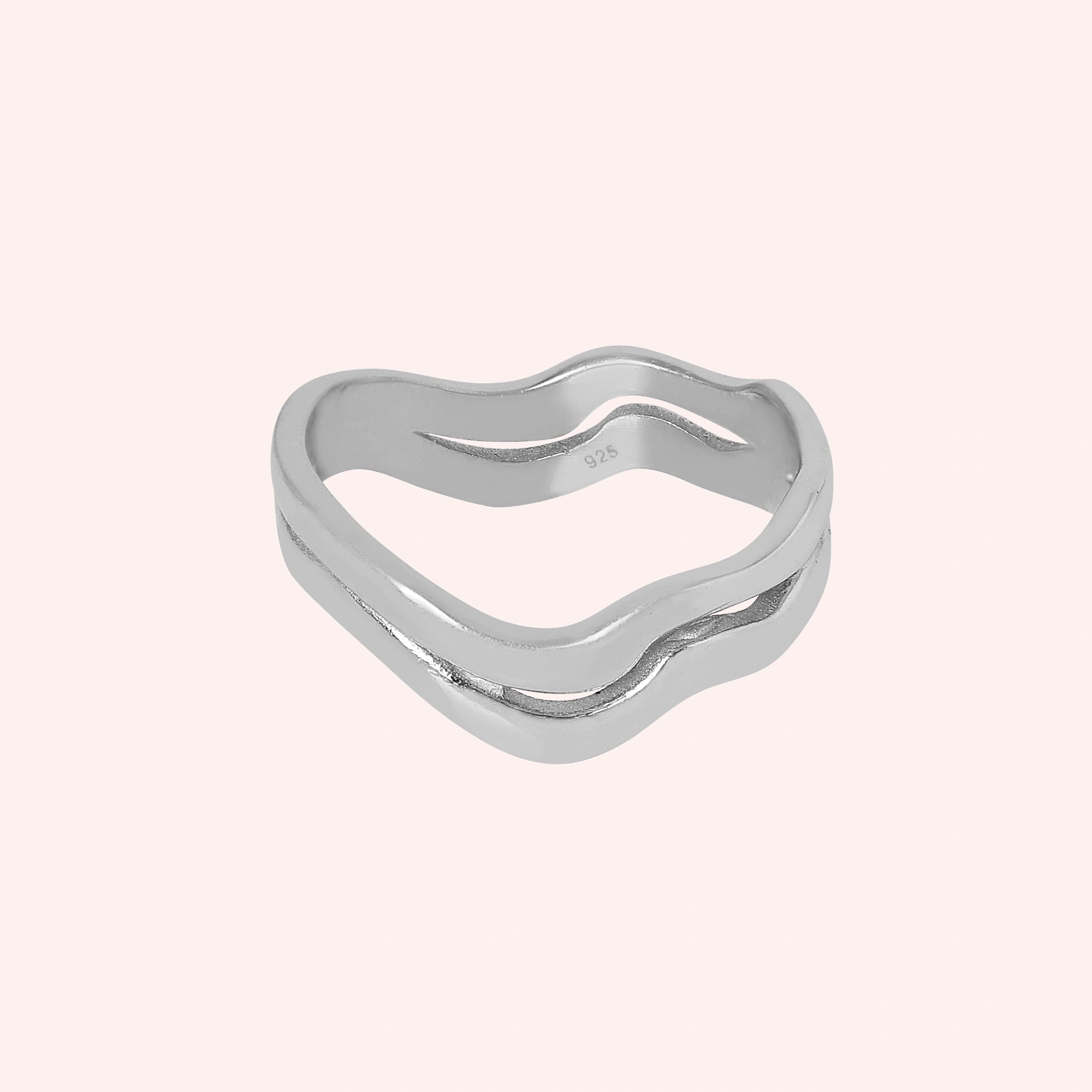A straight view of a double layered wave ring silver band ring with 925 stamp with an organic shape on a light pink background