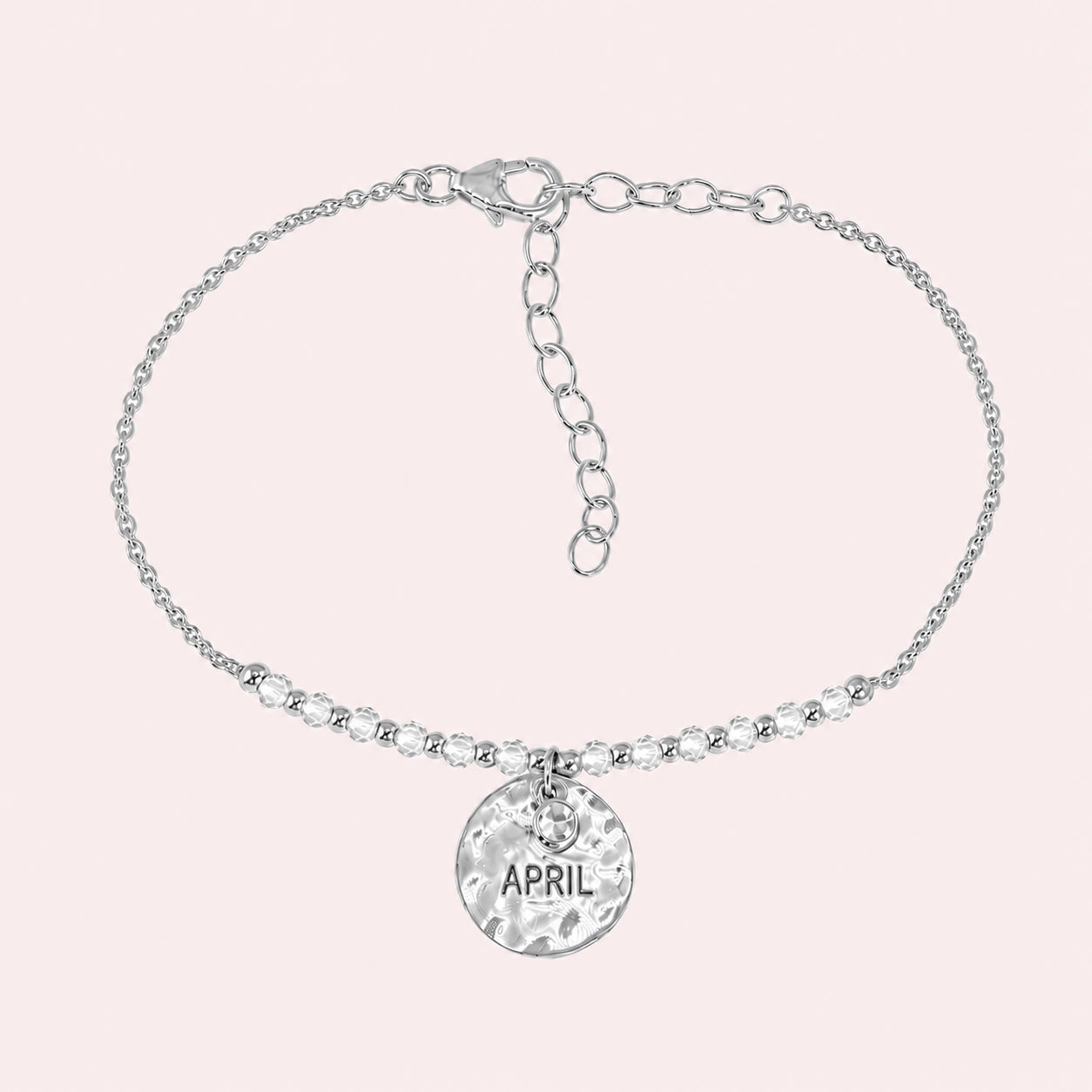 Birthstone_bracelet_in_sterling_silver_with_April_charm_and_white_topaz_beads_on_fine_chain_on_solid_pink_background