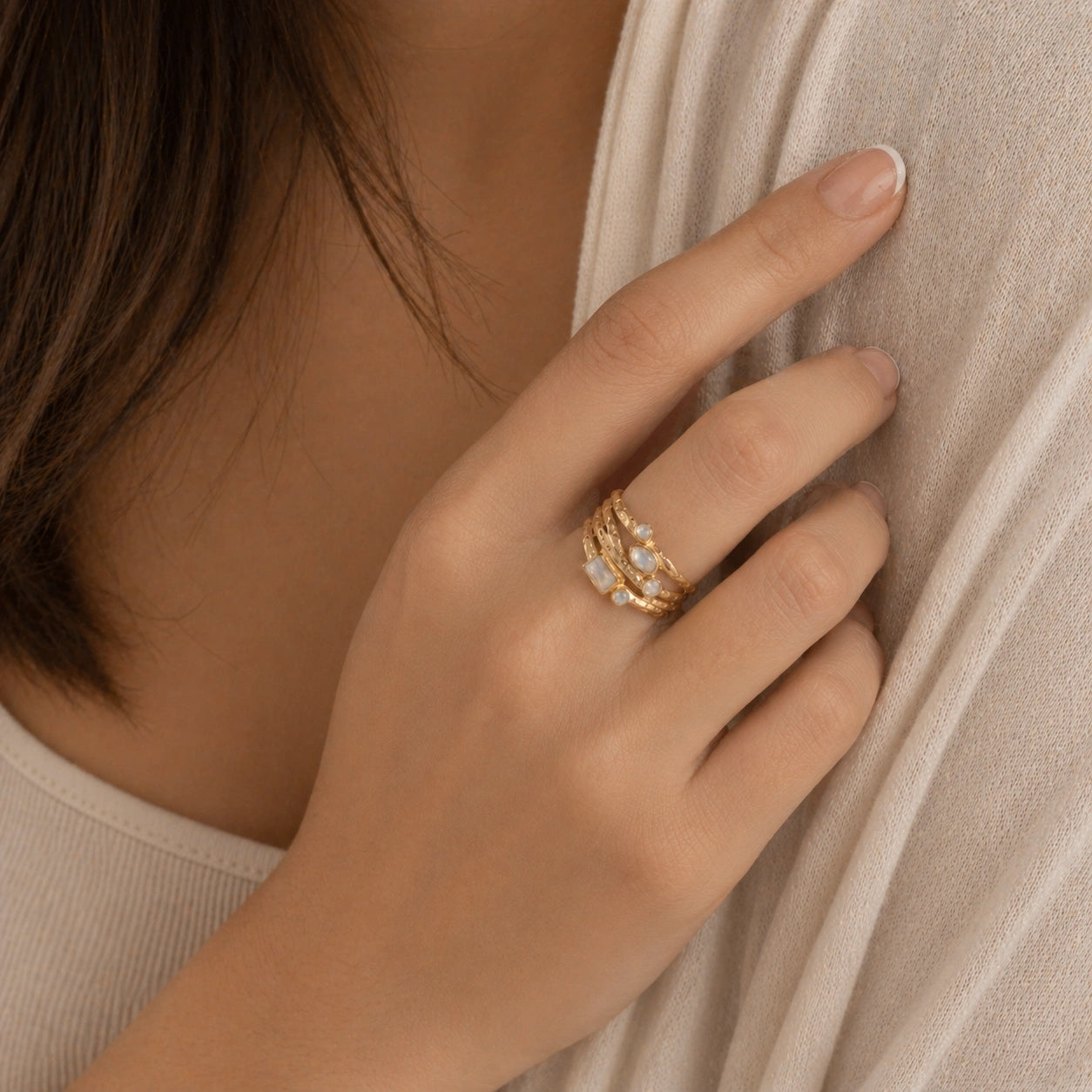 Wide_band_ring_in_gold_plated_silver_with_multiple_moonstones_worn_by_a_model