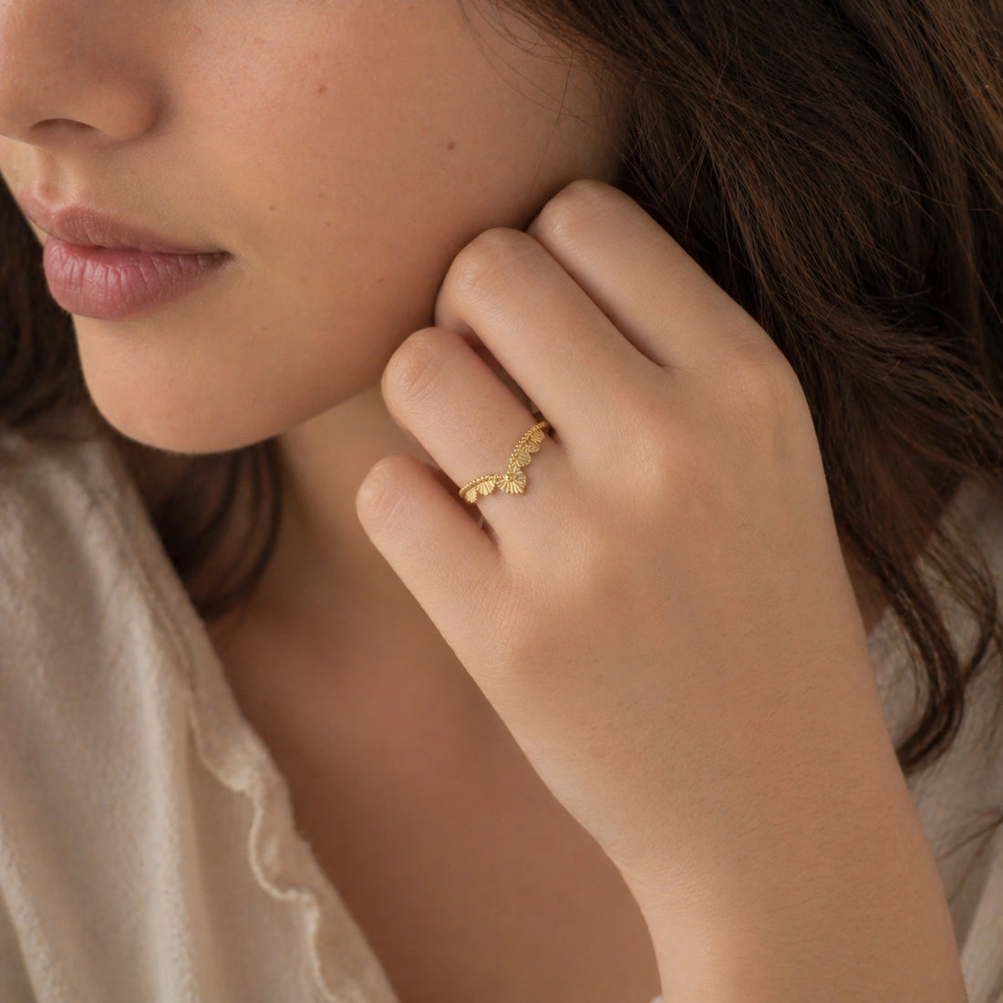 Wishbone_ring_in_gold_plated_silver_with_designed_v_shape_in_slightly_angled_view_on_soft_fabric_background
