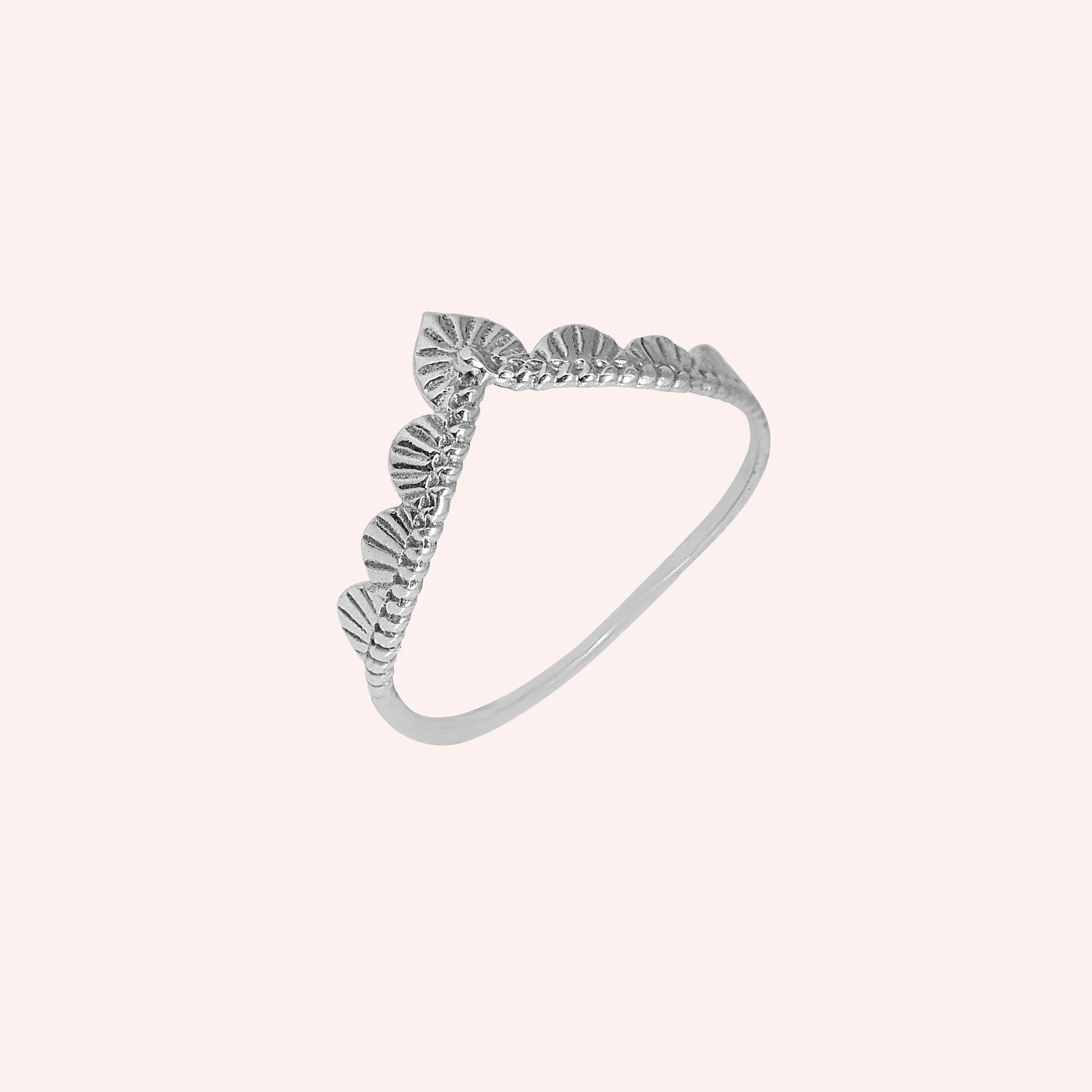 Wishbone_ring_in_sterling_silver_with_designed_v_shape_in_slightly_angled_view_on_solid_pink_background