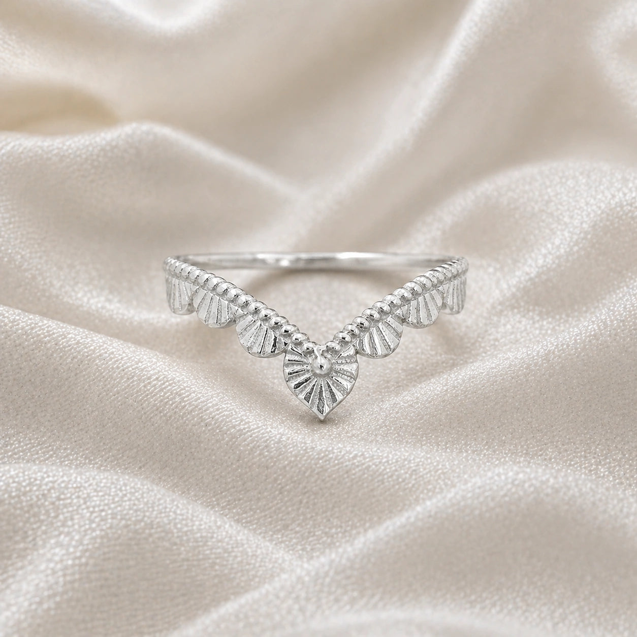 Wishbone_ring_in_sterling_silver_with_designed_v_shape_in_front_angle_view_on_soft_fabric_background
