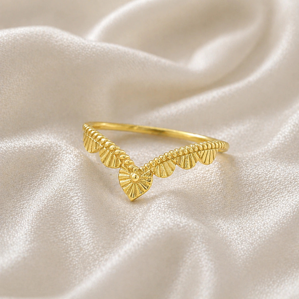 Wishbone_ring_in_gold_plated_silver_with_designed_v_shape_in_slightly_angled_view_on_soft_fabric_background